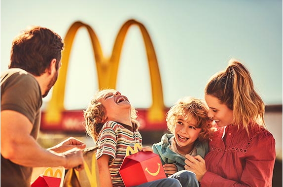 Familie mit Happy Meal vor McDonalds