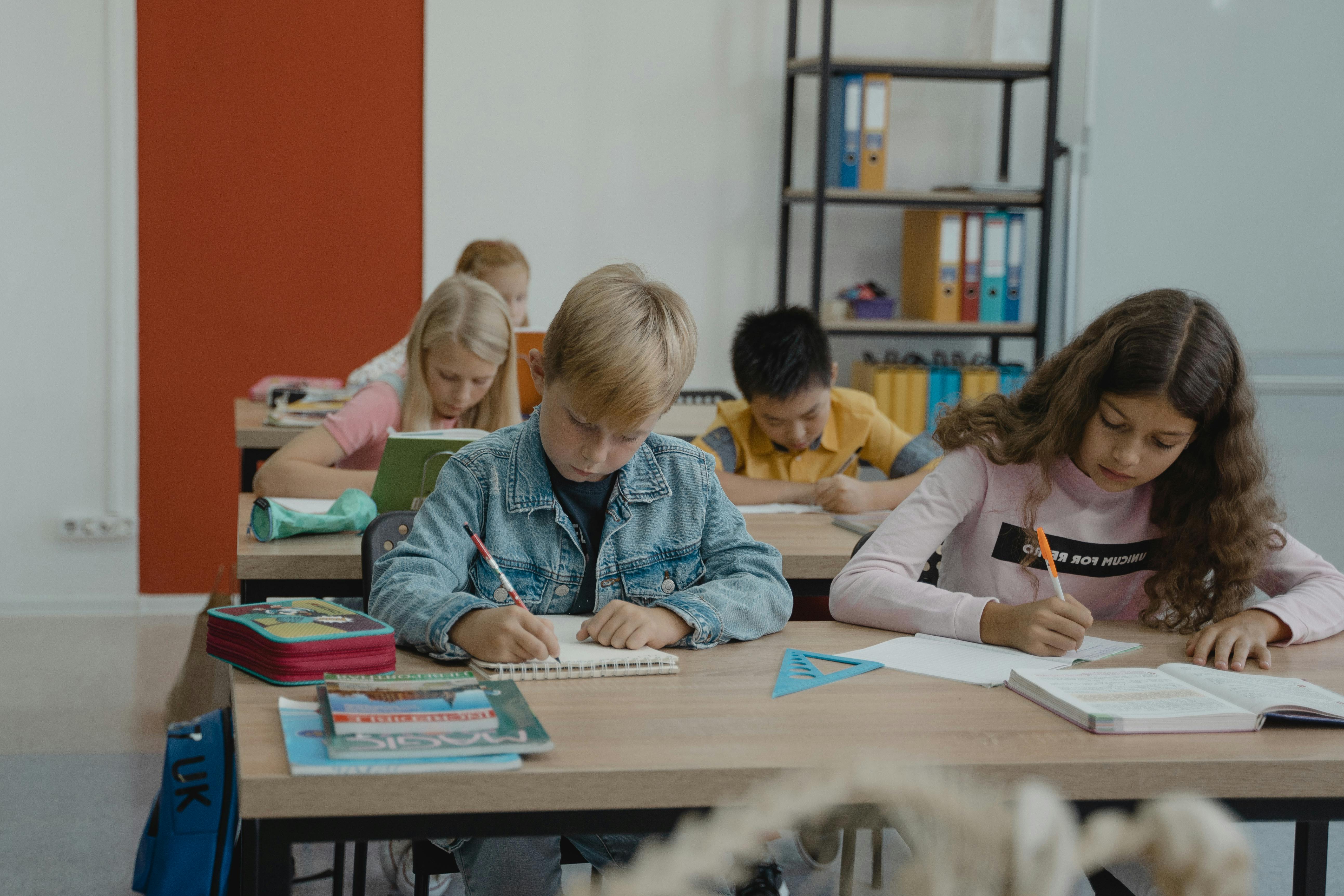 Kinder arbeiten in einem Klassenzimmer an ihren Aufgaben.